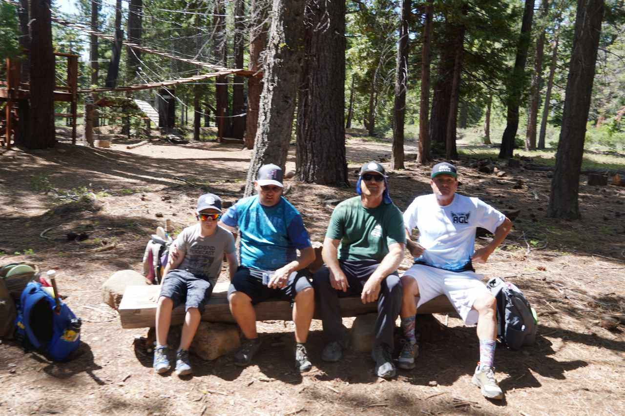 Disc golf players take a break on a bench